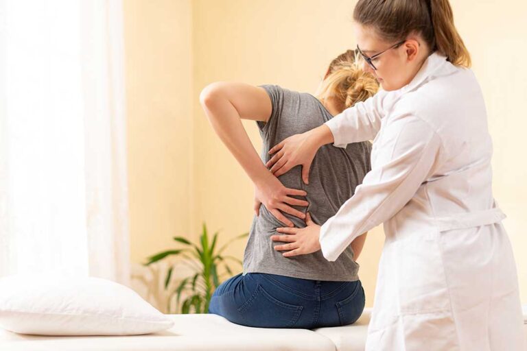 A person on a yoga mat in a living room gently stretching and rotating their neck and shoulders.