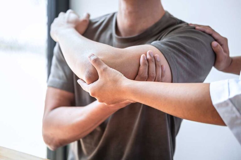 Person receiving a careful spinal adjustment in a bright clinical room while discussing mobility and fatigue.
