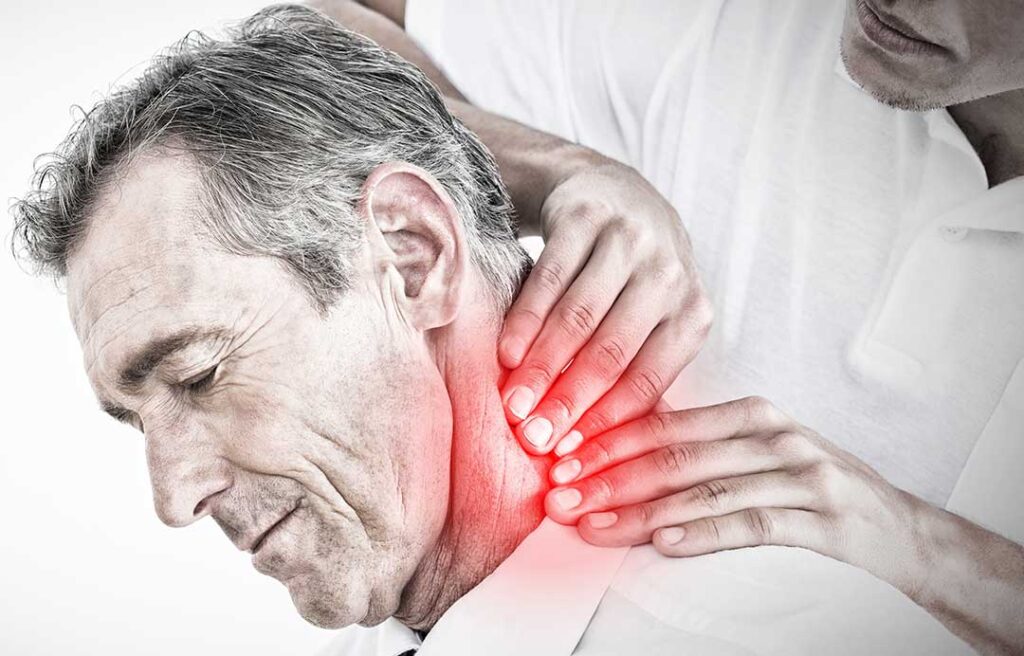 Adult receiving a gentle spine assessment while standing beside a treatment table.