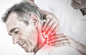 Adult receiving a gentle spine assessment while standing beside a treatment table.