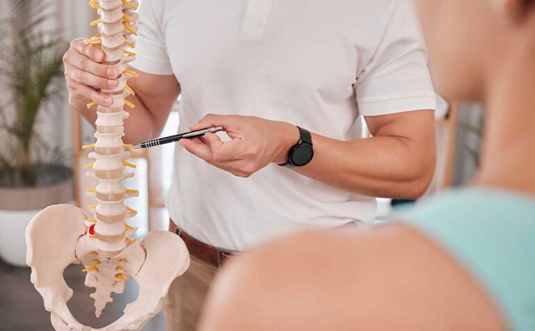 Athlete performing a balance exercise while a clinician observes lower-body movement in a bright therapy room.